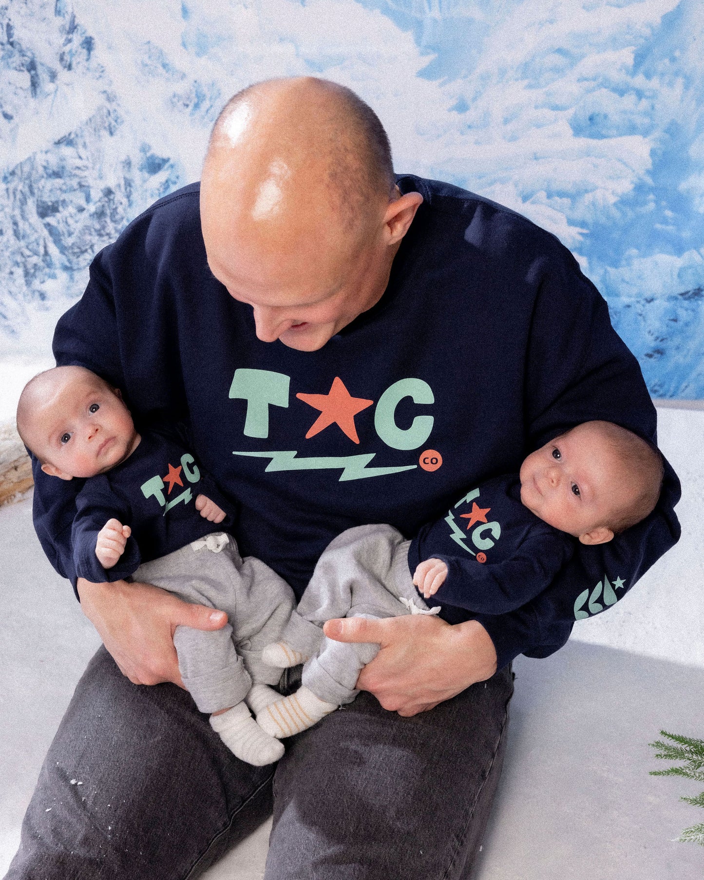 man holding two babies